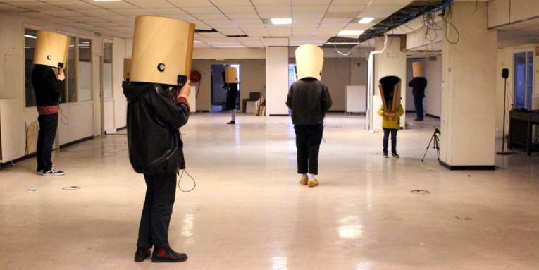 Menschen mit verdeckten Köpfen in einem Raum